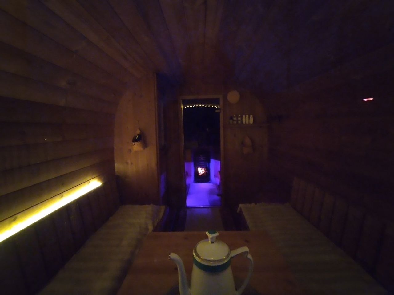 Fasssauna Innenansicht mit Teekanne und lila Licht